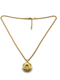 Gold necklace with a round pendant on a white background