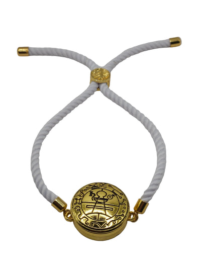 White bracelet with gold circular pendant on a light gray background